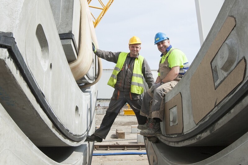 Zdjęcie 2013 r. Pracownicy pozujący na betonowych elementach, z których wykonane są rury tunelu 4